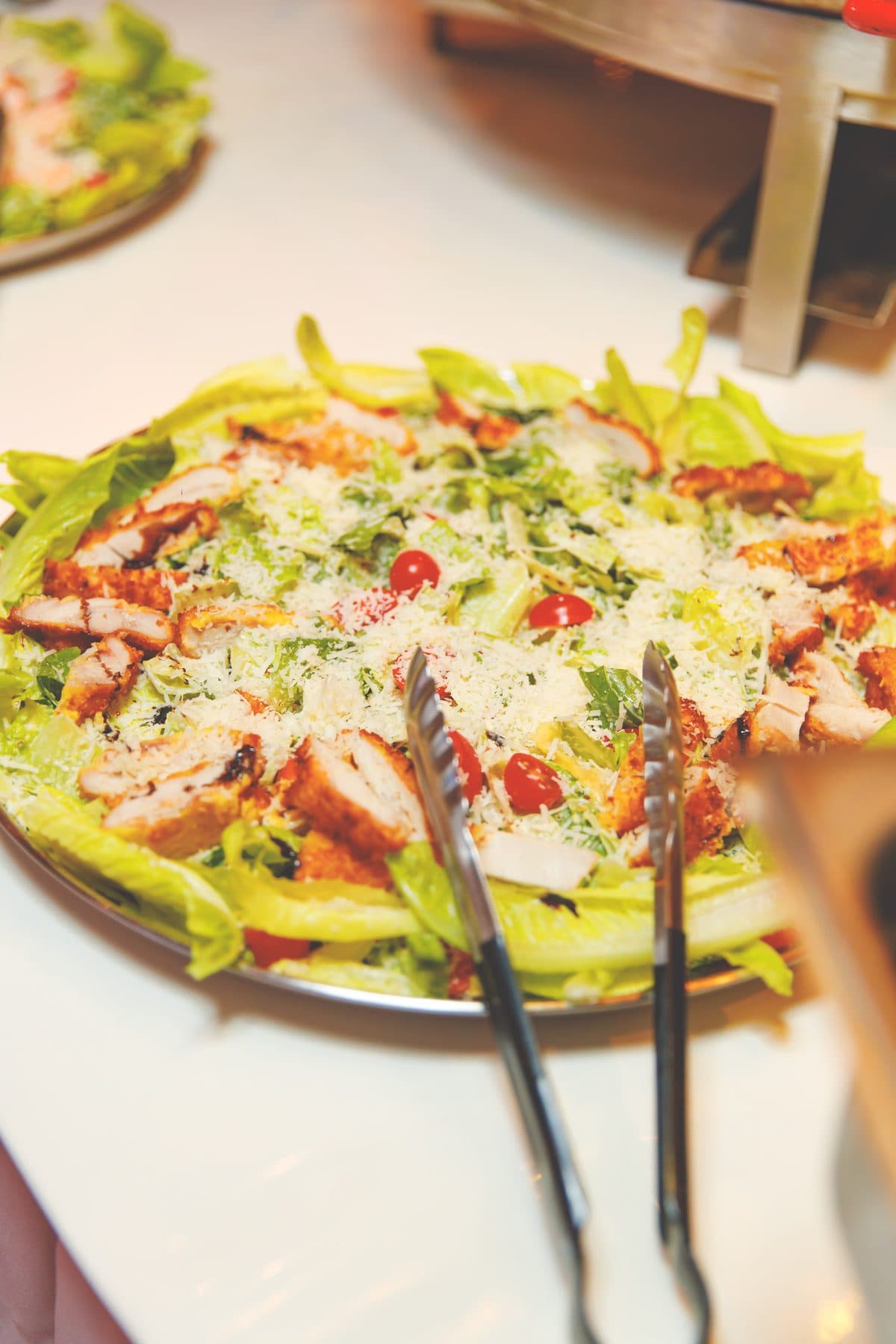 Salatplatte mit Hähnchen, Kirschtomaten und Parmesan am Buffet
