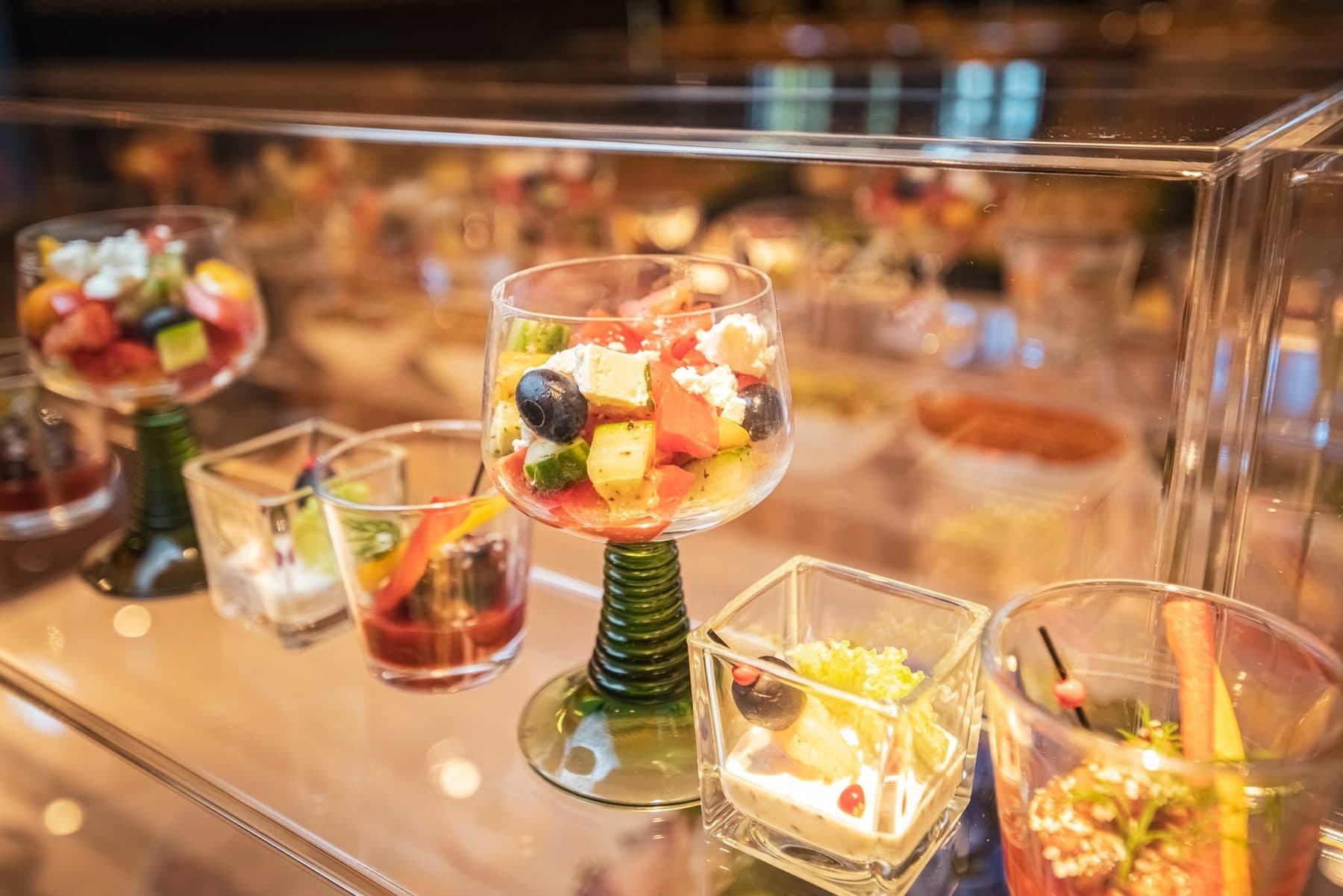 Salate in kleinen Glaskübeln mit Henkel auf dem Buffet